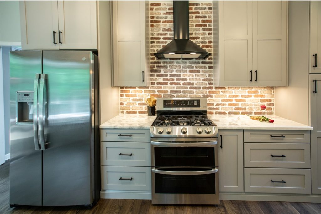 kitchen with white cabinets and brick backsplash