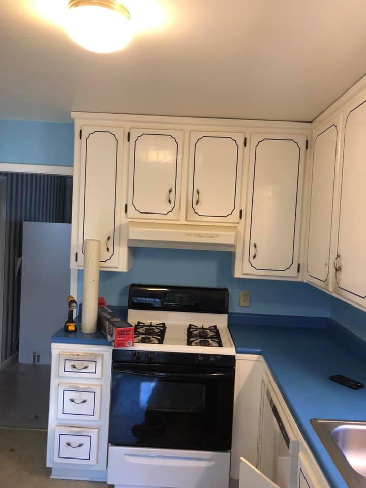 small kitchen with white cabinets and blue accent