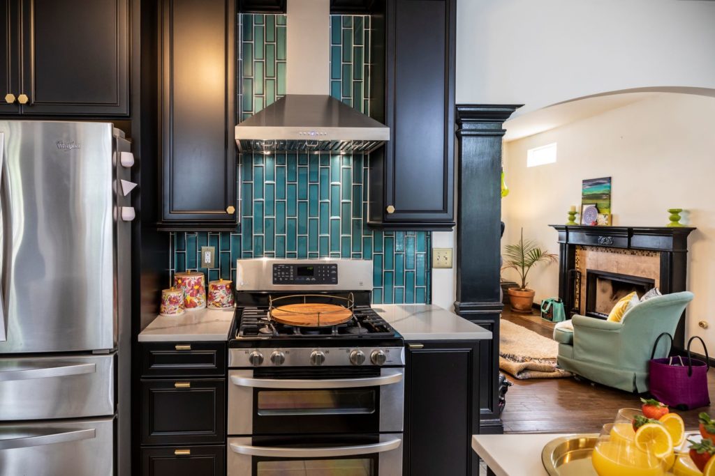kitchen with black cabinets and blue backsplash