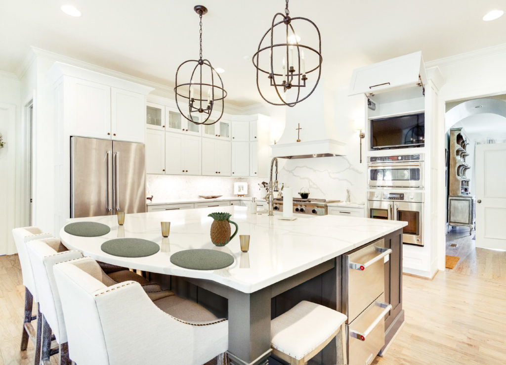 white kitchen with island and chandeliers 